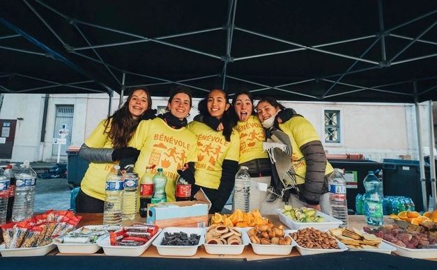 Bénévoles en t-shirts jaunes derrière une table de ravitaillement
